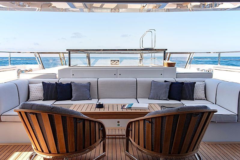 a couch and a table on a deck overlooking a large body of water aboard LADY LENA Yacht for Charter