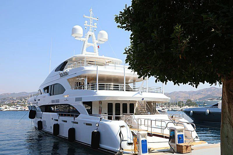 a large white boat in a harbor aboard ILERIA Yacht for Charter