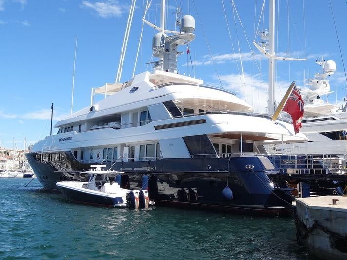 a large boat docked at a pier aboard REVERIE Yacht for Charter