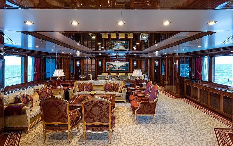 a large living room with a large chandelier aboard KADIMO'S Yacht for Charter
