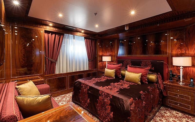 a large bedroom with a bed and a couch aboard KADIMO'S Yacht for Charter