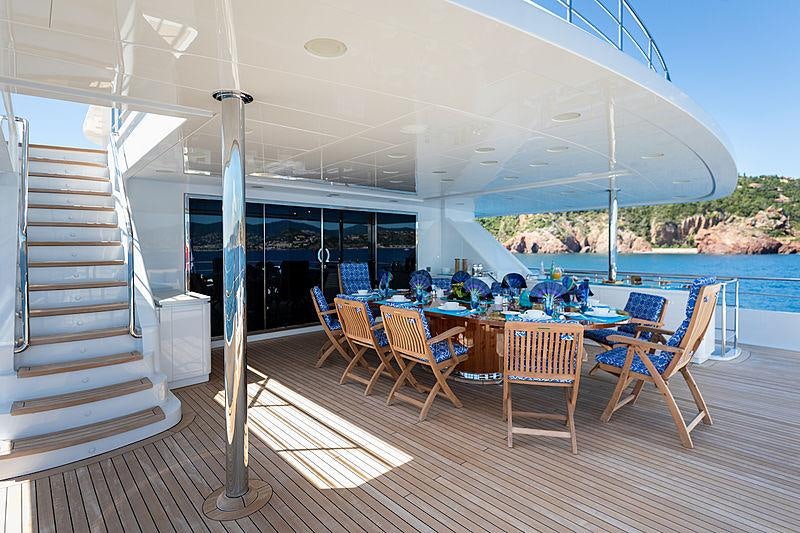 a deck with a table and chairs aboard KADIMO'S Yacht for Charter