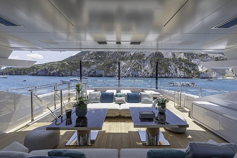 a room with a table and chairs on it by a body of water aboard LEL Yacht for Charter