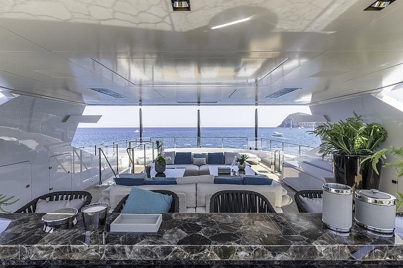 a room with a large table and chairs and a large window aboard LEL Yacht for Charter