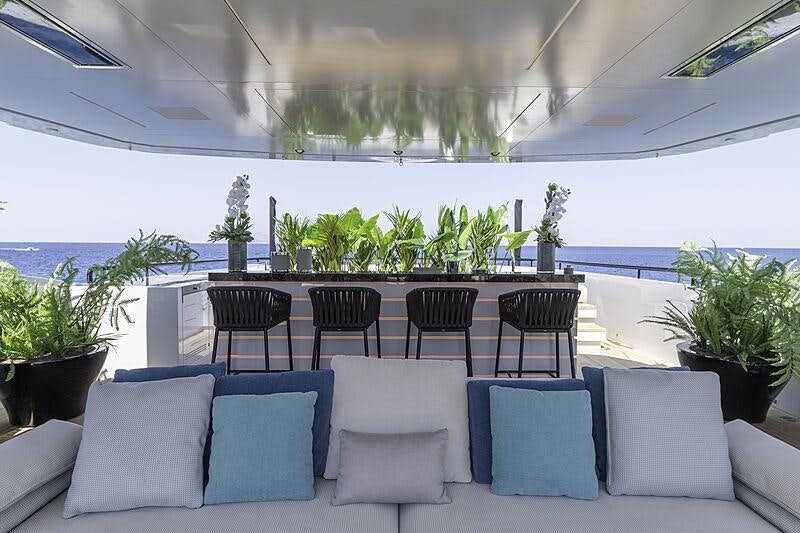 a large room with chairs and plants aboard LEL Yacht for Charter
