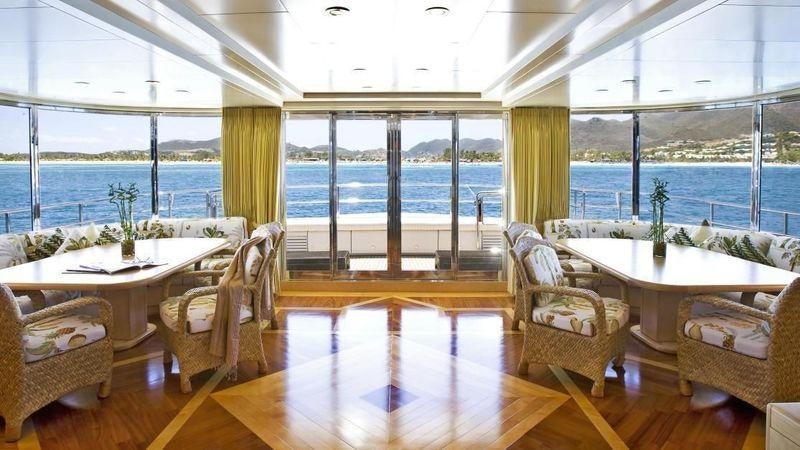 a room with a table chairs and a large window aboard TE MANU Yacht for Charter