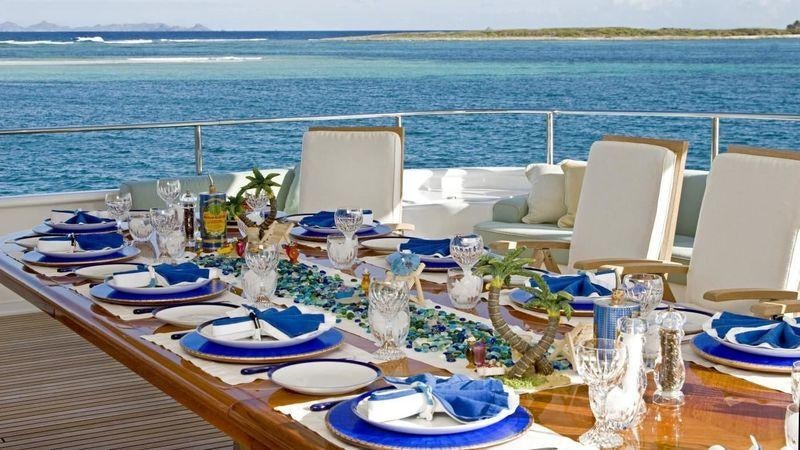 a table set for a dinner party aboard TE MANU Yacht for Charter