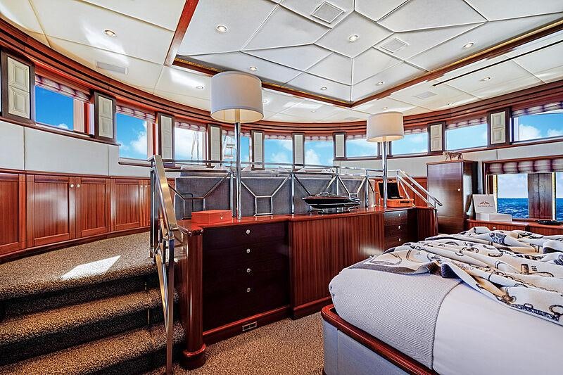 a room with a bed and a desk aboard OCEAN CLUB Yacht for Charter