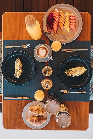 a table with plates of food and silverware aboard KUDANIL EXPLORER Yacht for Charter