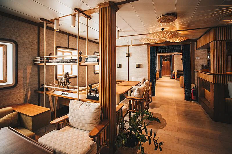 a room with a table chairs and a piano aboard KUDANIL EXPLORER Yacht for Charter