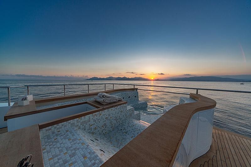 a deck with a view of the sunset and water aboard MY MAYVA Yacht for Charter