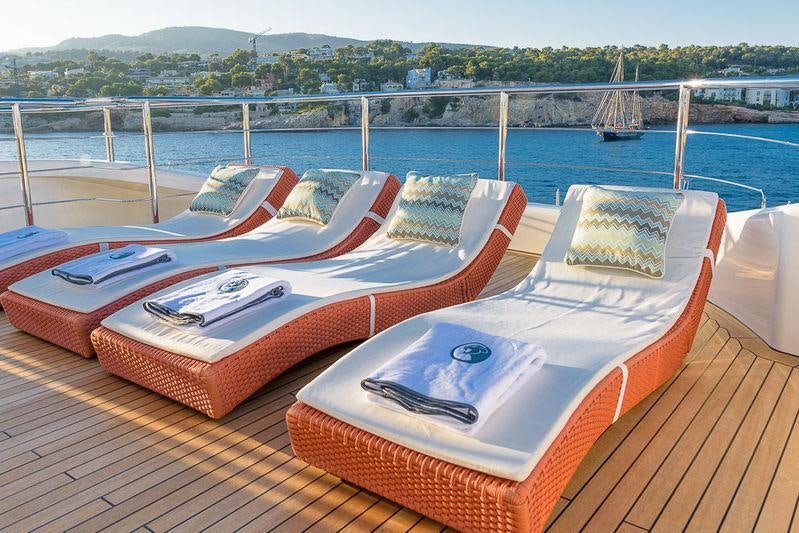 a lounge chair on a deck overlooking a body of water aboard AFRICA I Yacht for Charter