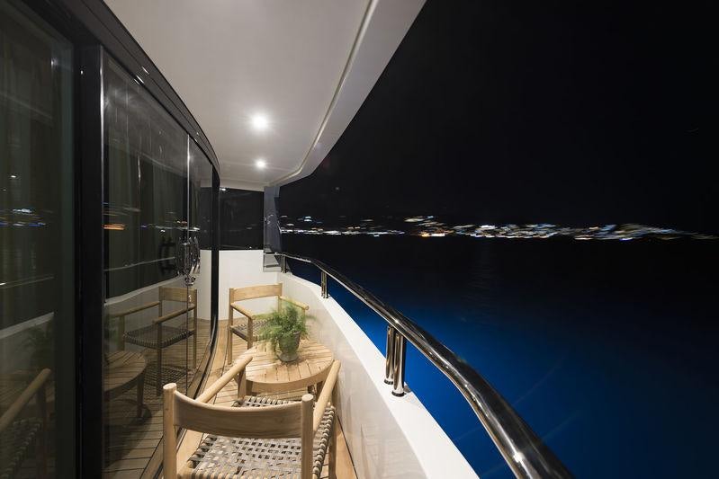 a balcony with a view of the water and the city below aboard LIQUID SKY Yacht for Charter