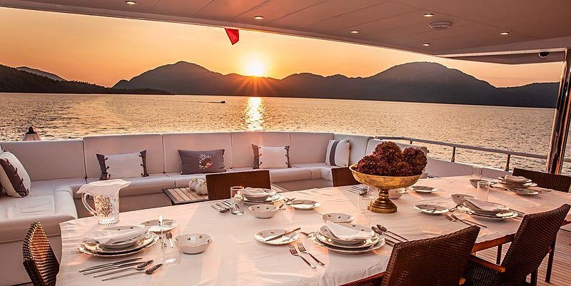 a large room with a table and chairs and a large window aboard OCEAN BREEZE Yacht for Charter