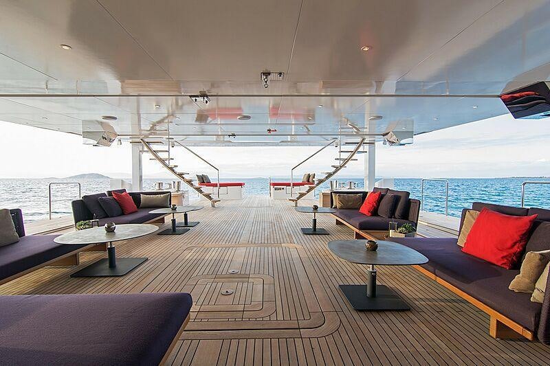 a room with a couch and a table and a large window aboard MY EDEN Yacht for Charter