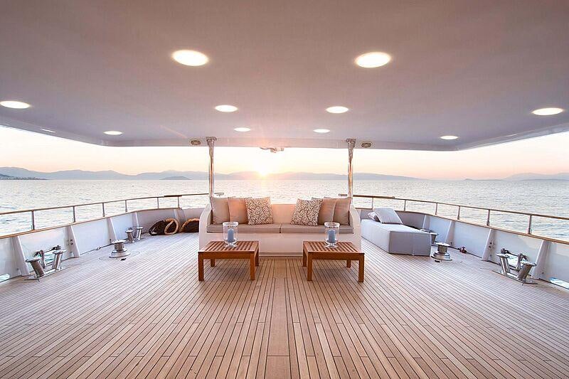 a large room with a couch and a table and a large body of water aboard BELLA STELLA Yacht for Charter