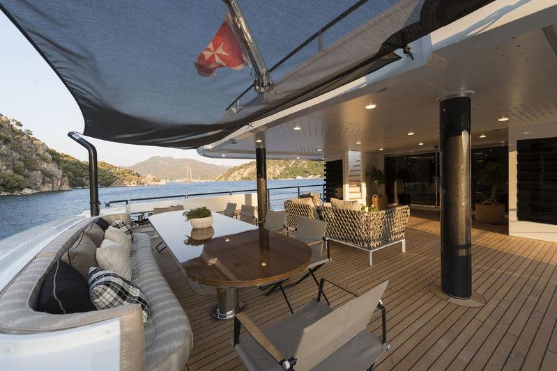 a patio with a table and chairs on it aboard AQUARIUS Yacht for Charter
