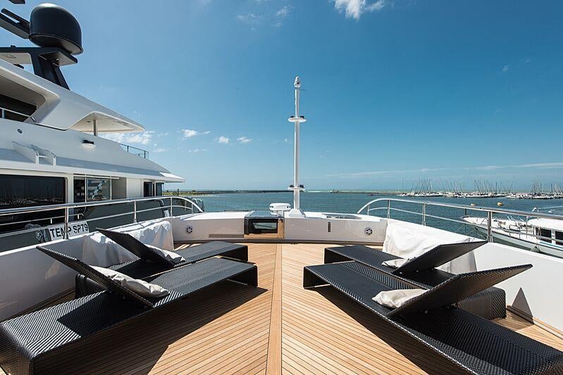 a deck with a view of the water and a tower in the background aboard FAST & FURIOUS Yacht for Charter