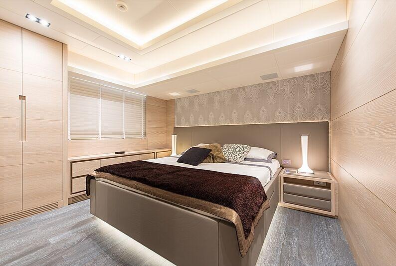 a bedroom with a bed and a lamp aboard FAST & FURIOUS Yacht for Charter