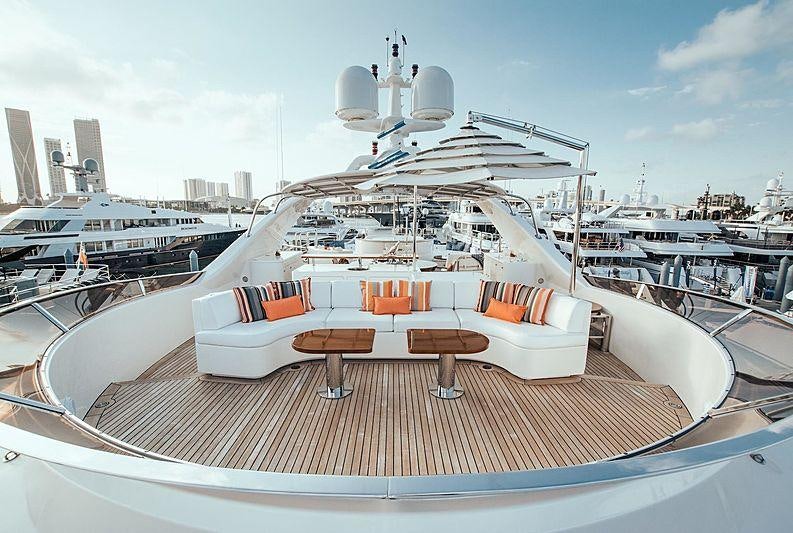 a large white yacht with a table and chairs on a deck aboard ALEGRIA Yacht for Charter