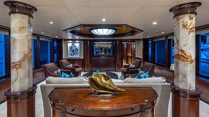 a large living room with a large table and chairs aboard STARSHIP Yacht for Charter