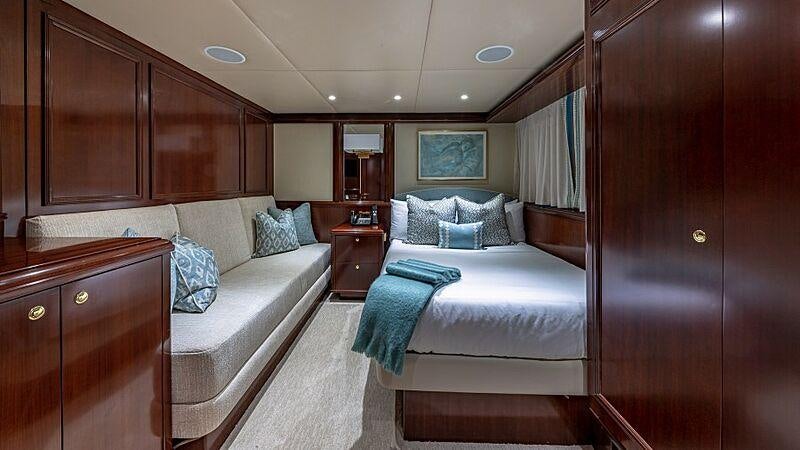 a bedroom with a bed and a dresser aboard STARSHIP Yacht for Charter