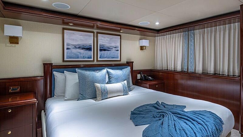 a bed with a blue blanket aboard STARSHIP Yacht for Charter