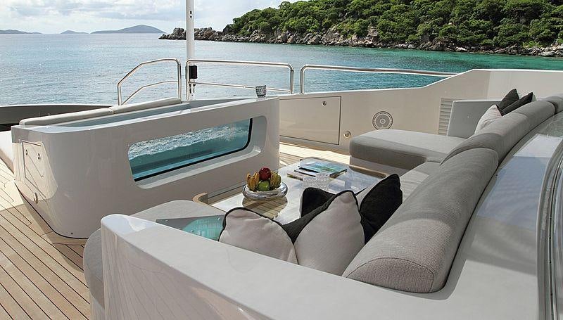 a white couch with a pool in the background aboard MUCHOS MAS Yacht for Charter