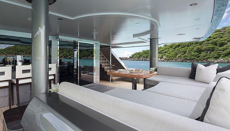 a room with a couch and a table and a window aboard MUCHOS MAS Yacht for Charter