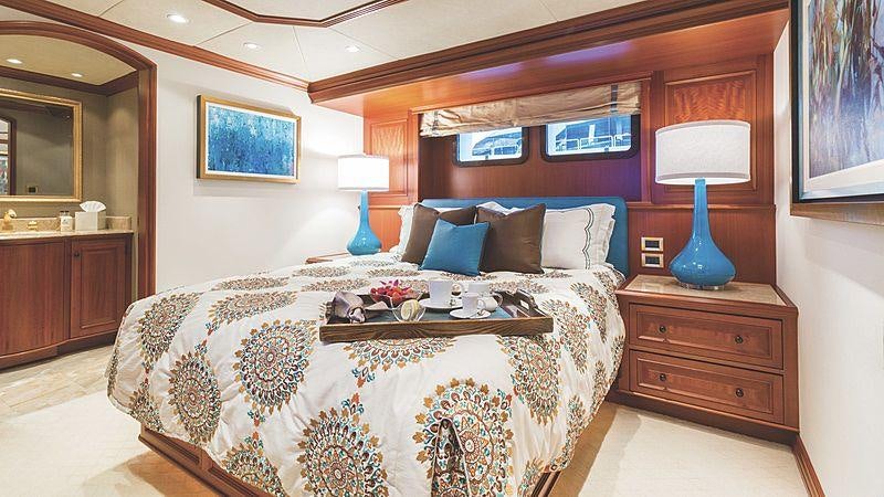 a bed with a blue and white bed spread aboard CROSSED SABRE Yacht for Charter