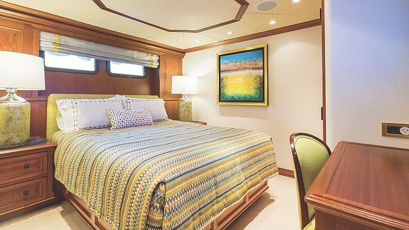 a bedroom with a bed and a desk aboard CROSSED SABRE Yacht for Charter