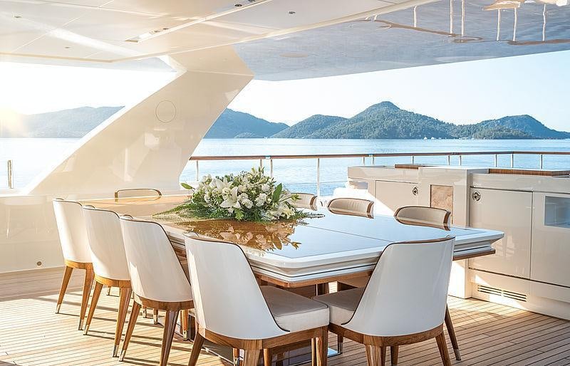 a table and chairs on a deck aboard SUNRISE Yacht for Charter