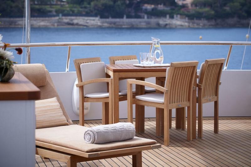 a table and chairs on a deck overlooking a body of water aboard GO Yacht for Charter