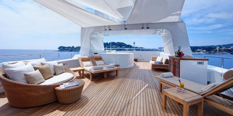 a room with a couch and a table and a view of the water aboard GO Yacht for Charter