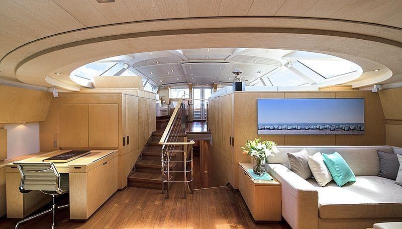 a room with a couch and a table and a staircase aboard GUILLEMOT Yacht for Charter
