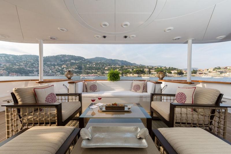 a room with couches and a table and chairs aboard BINA Yacht for Charter