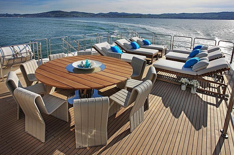 a table and chairs on a deck overlooking a body of water aboard LADY I Yacht for Charter