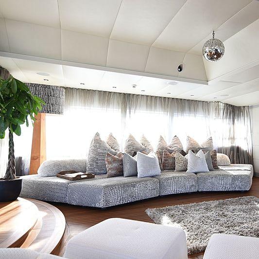 a living room with a large blue couch and white walls aboard LIFE SAGA Yacht for Charter