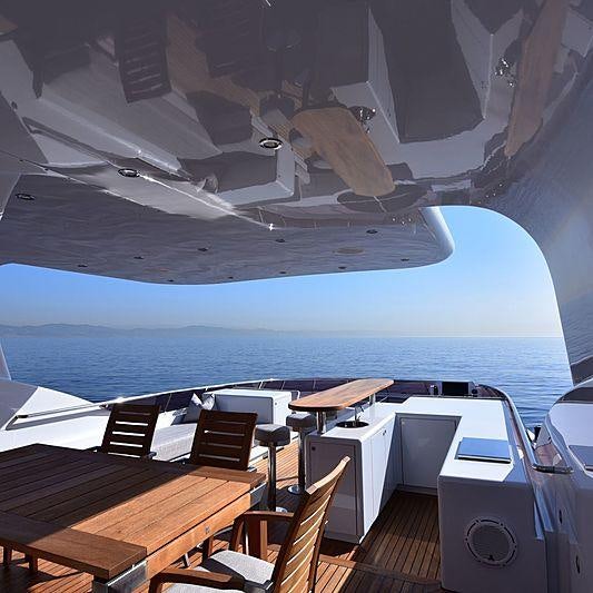 a deck with a view of the ocean and a large cruise ship aboard LIFE SAGA Yacht for Charter