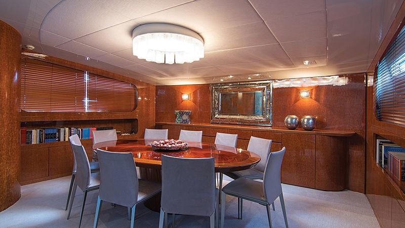 a room with a table chairs and a bookcase aboard CONDOR A Yacht for Charter