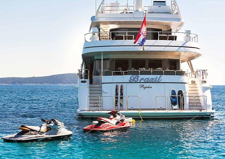 a boat and a motor boat in the water aboard BRAZIL Yacht for Charter