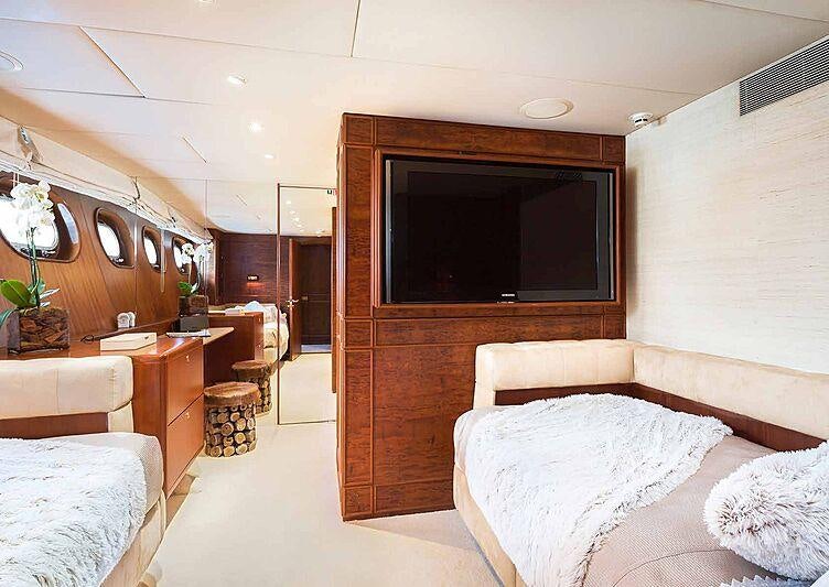 a room with a bed and a television aboard BRAZIL Yacht for Charter