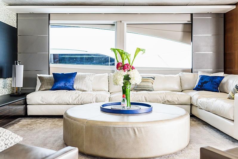 a living room with a white couch and a vase of flowers on a table aboard IMPERIAL PRINCESS BEATRICE Yacht for Charter