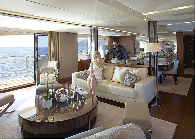 a man and woman standing in a living room aboard IMPERIAL PRINCESS BEATRICE Yacht for Charter