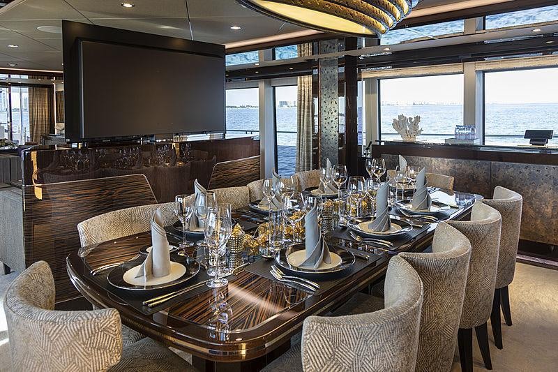a large dining table in a restaurant aboard SONISHI Yacht for Charter