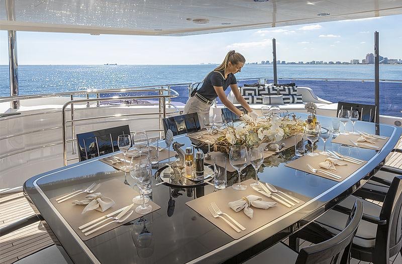 a person working on the laptop at a restaurant aboard SONISHI Yacht for Charter
