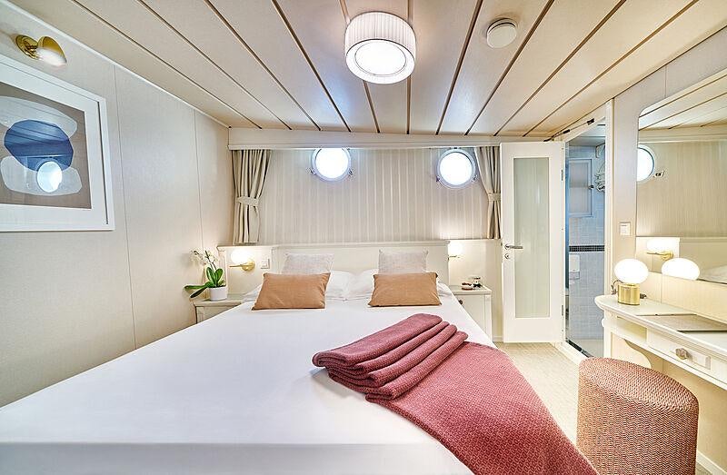 a large bed in a hotel room aboard LA PERLA Yacht for Charter