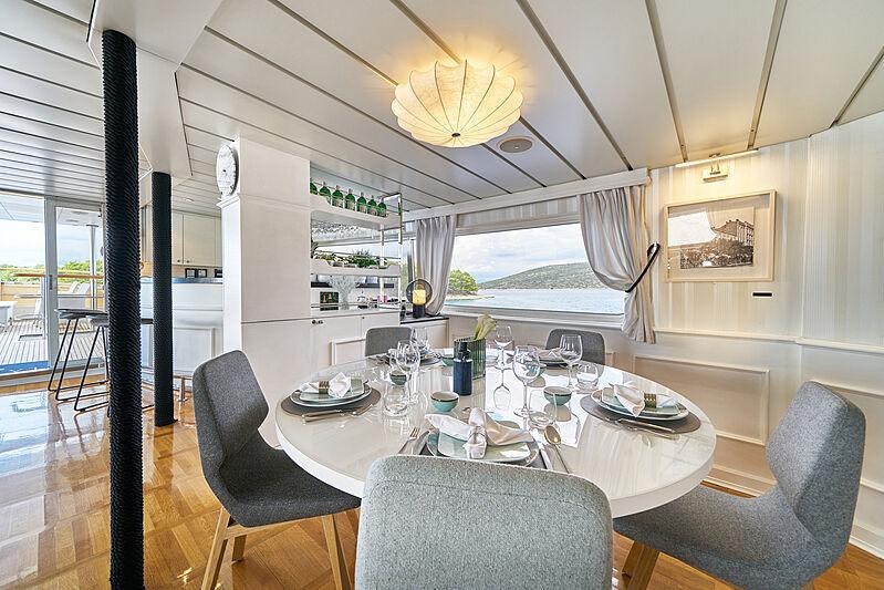 a dining room with a large window aboard LA PERLA Yacht for Charter