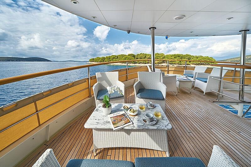 a table on a deck aboard LA PERLA Yacht for Charter