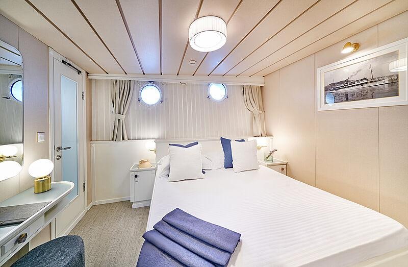 a room with a bed and a desk aboard LA PERLA Yacht for Charter